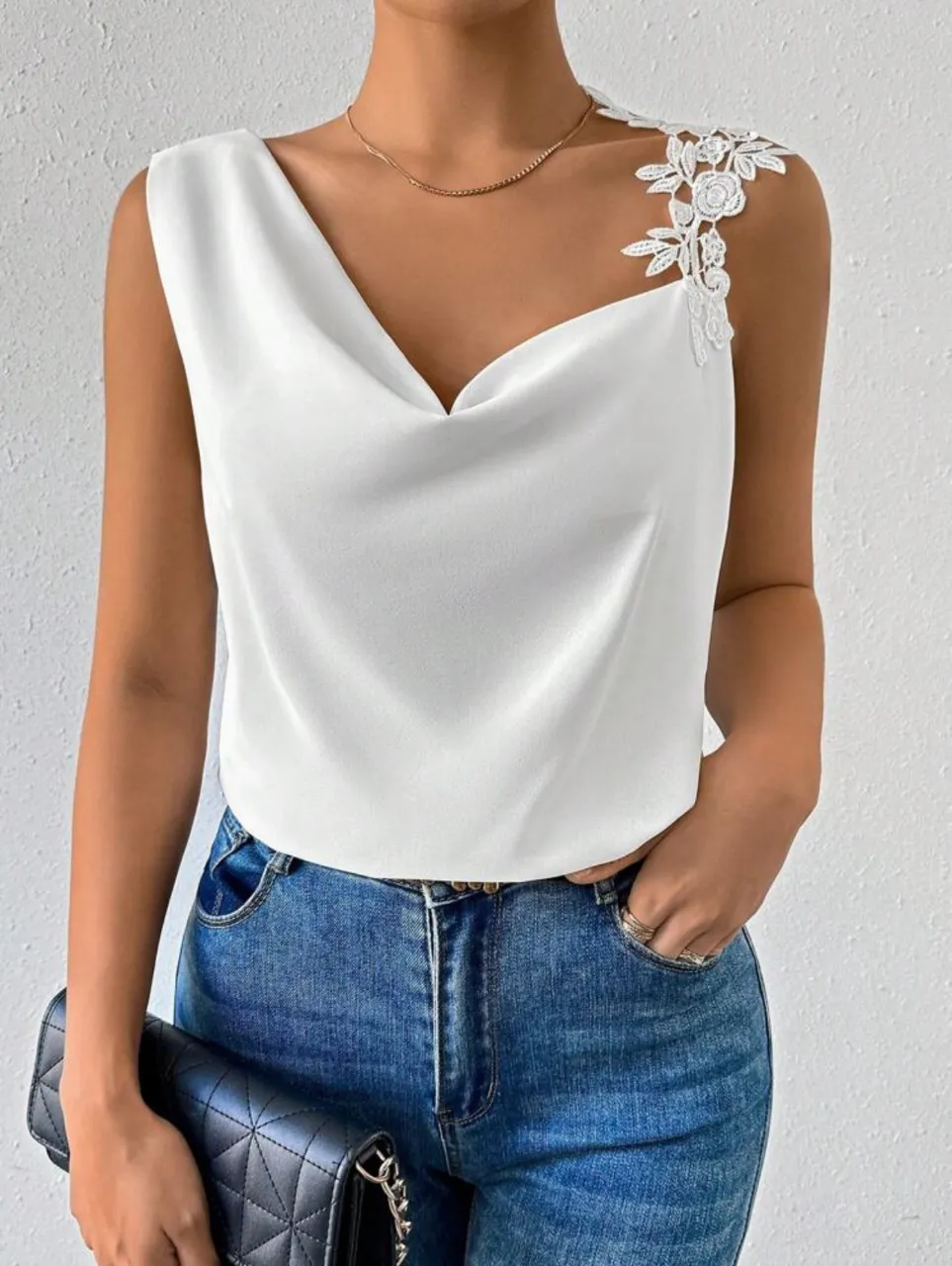 Top blanco con detalle de encaje en el hombro. Diseño asimétrico con cuello en V y corte elegante. Ideal para combinar con jeans.