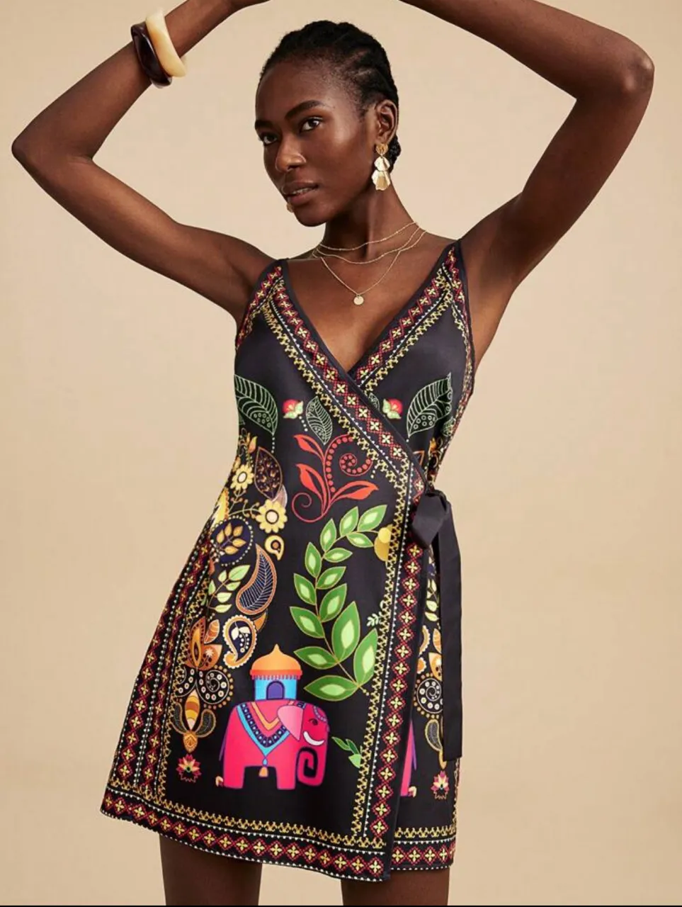 Vestido midi con estampado floral y de elefantes. Diseño envolvente con lazo en la cintura. Ideal para un look bohemio y elegante.