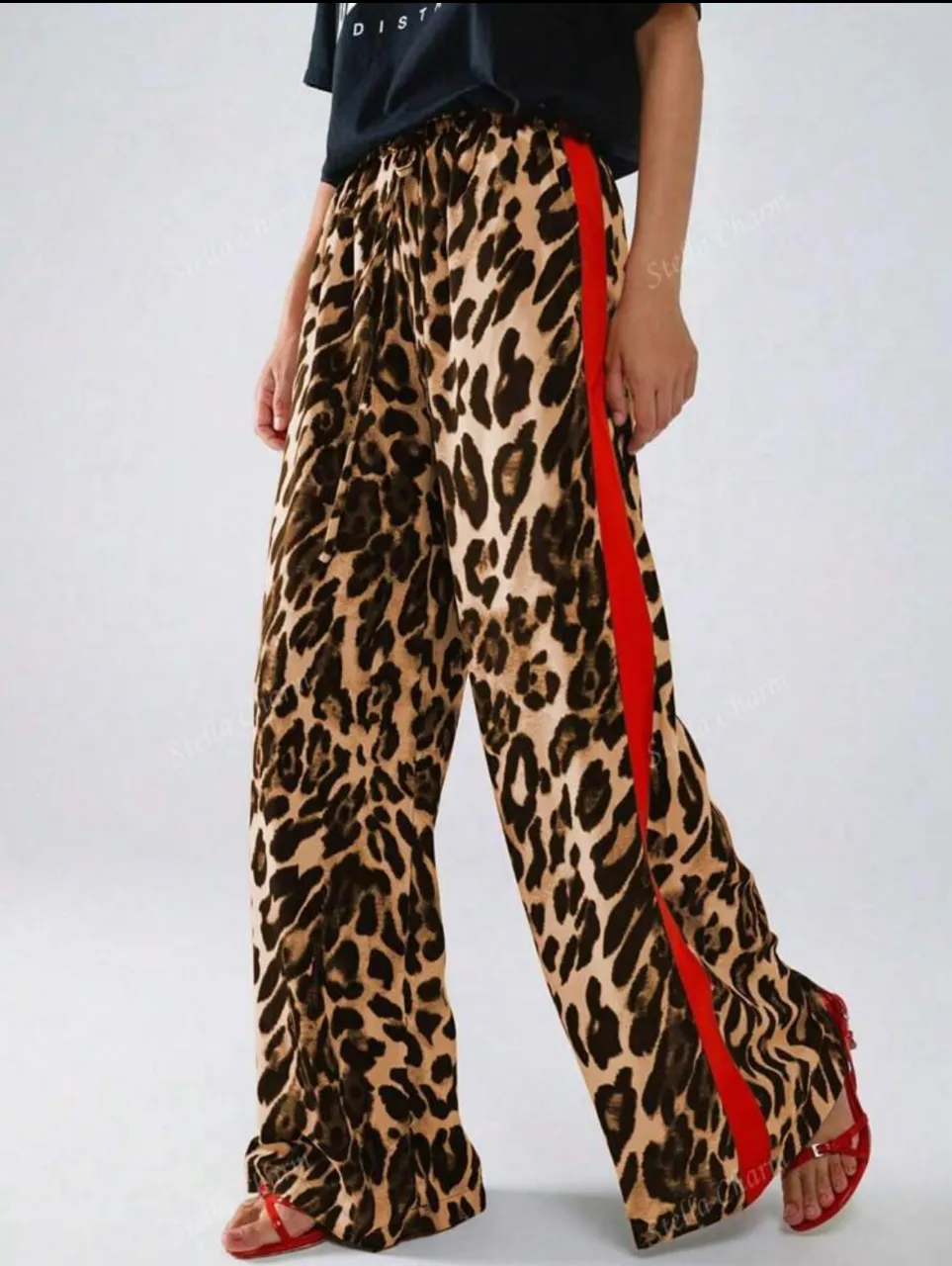 Pantalón suelto de mujer con estampado de leopardo y franja lateral roja. Ideal para un look casual y moderno.