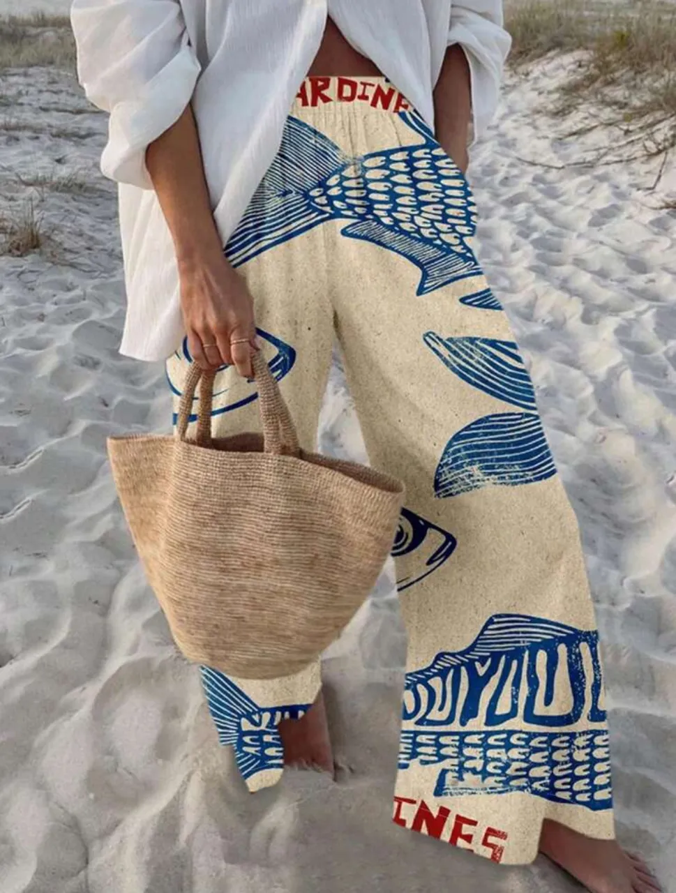 Pantalón suelto de mujer con estampado de peces en tonos azul y blanco. Ideal para un look playero o casual de verano. Diseño artesanal y cómodo.