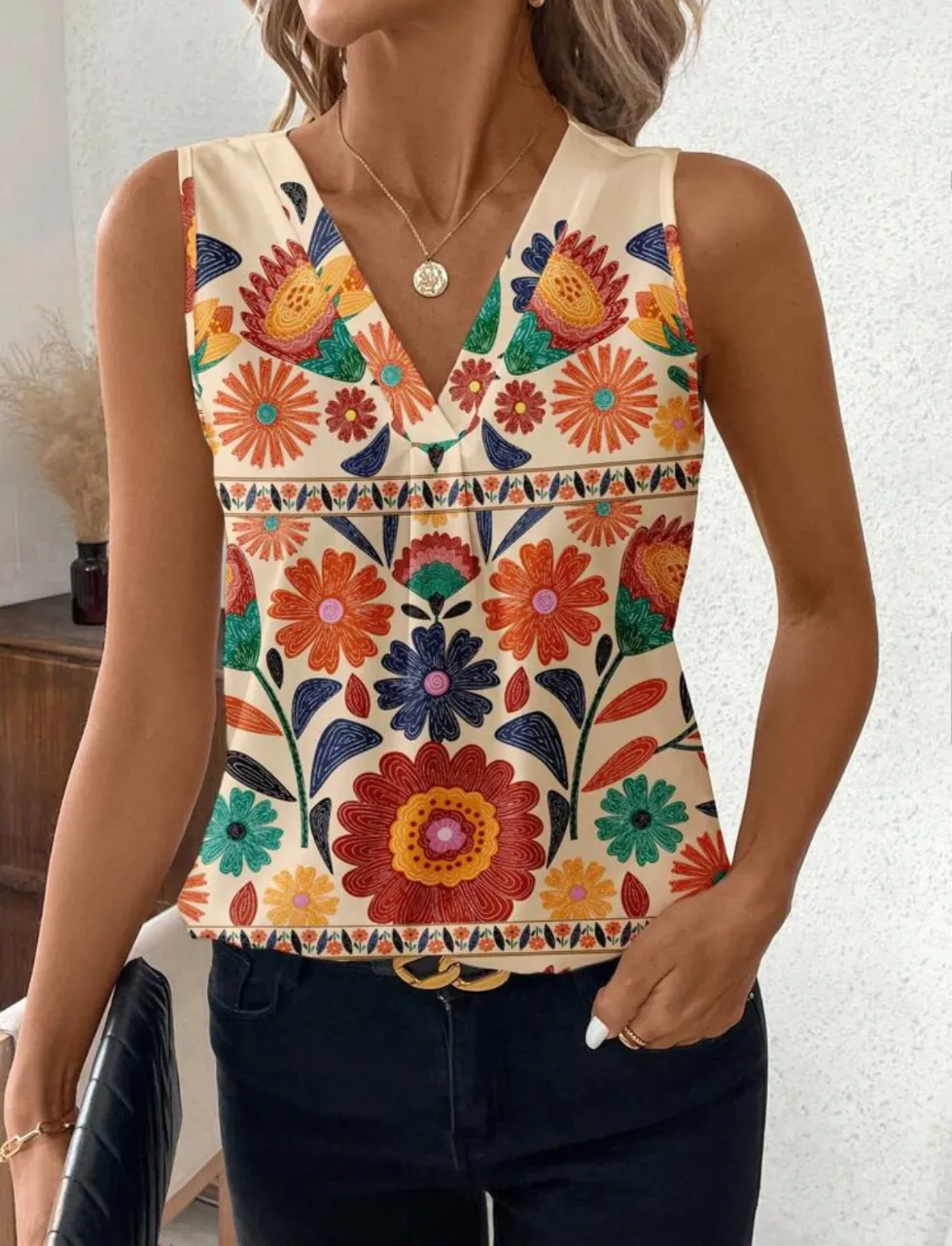Blusa sin mangas con estampado floral vibrante, escote en V y detalles decorativos. Ideal para un look bohemio y fresco.