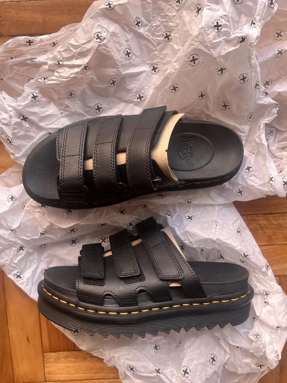 Sandalias Dr. Martens negras con tiras ajustables. Ideales para un look casual y cómodo.