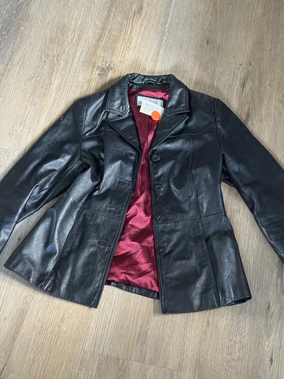 Campera de cuero negra, estilo blazer, con forro interno color bordó. Posee botones al frente y bolsillos. Tiene dos detalles: 1) adentro una manchita en el forro 2) afuera dos marquitas gastadas (ultima foto). es 100% cuero, se puede usar cerrada o abierta. 