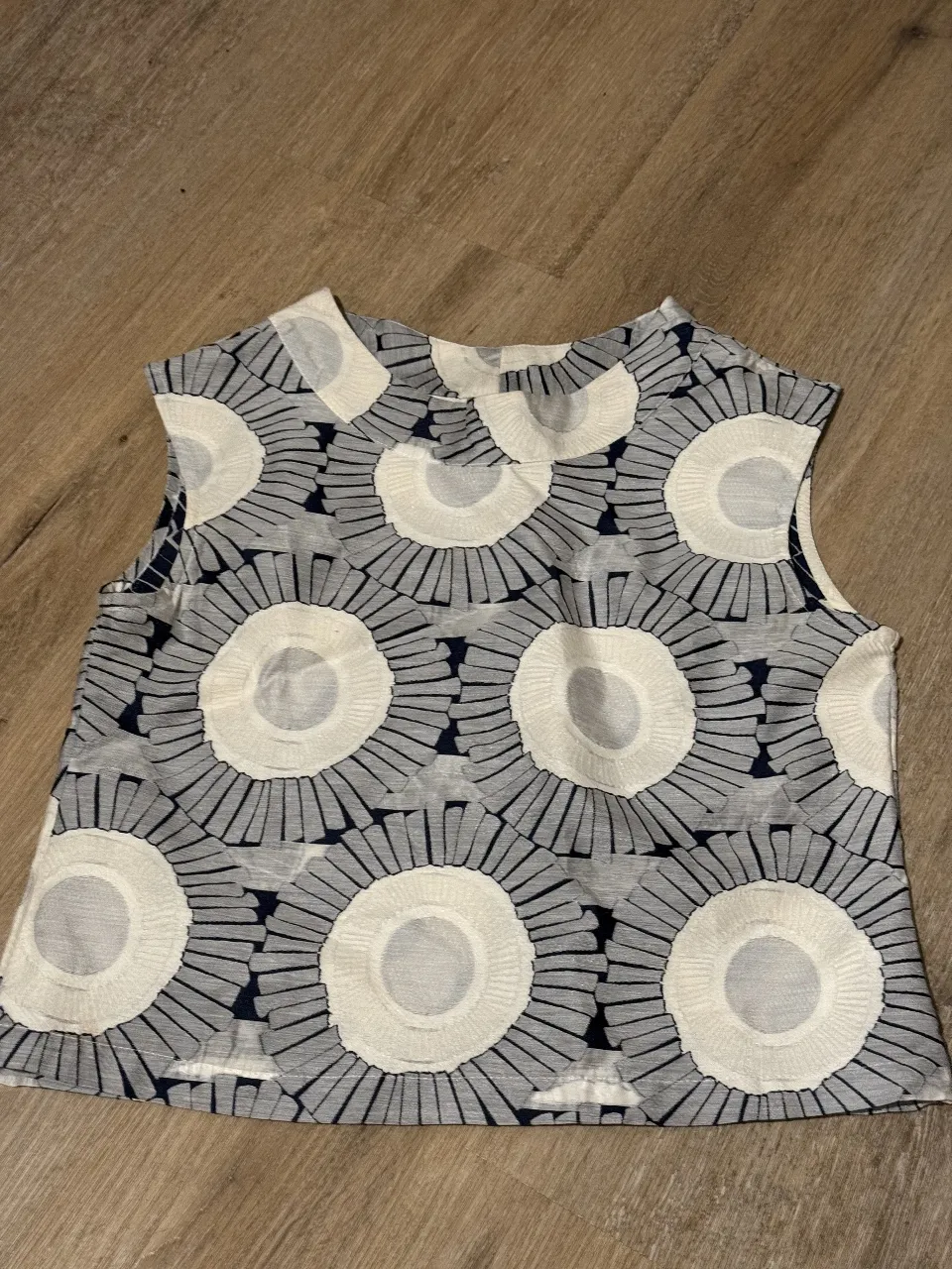 Top sin mangas con estampado floral en tonos blanco y azul.  Ideal para un look fresco y moderno. Tiene una manchita muy sutil a la altura de la axila derecha. en la ultima foto se puede ver. Es talle 0 pero es mas bien un m/s