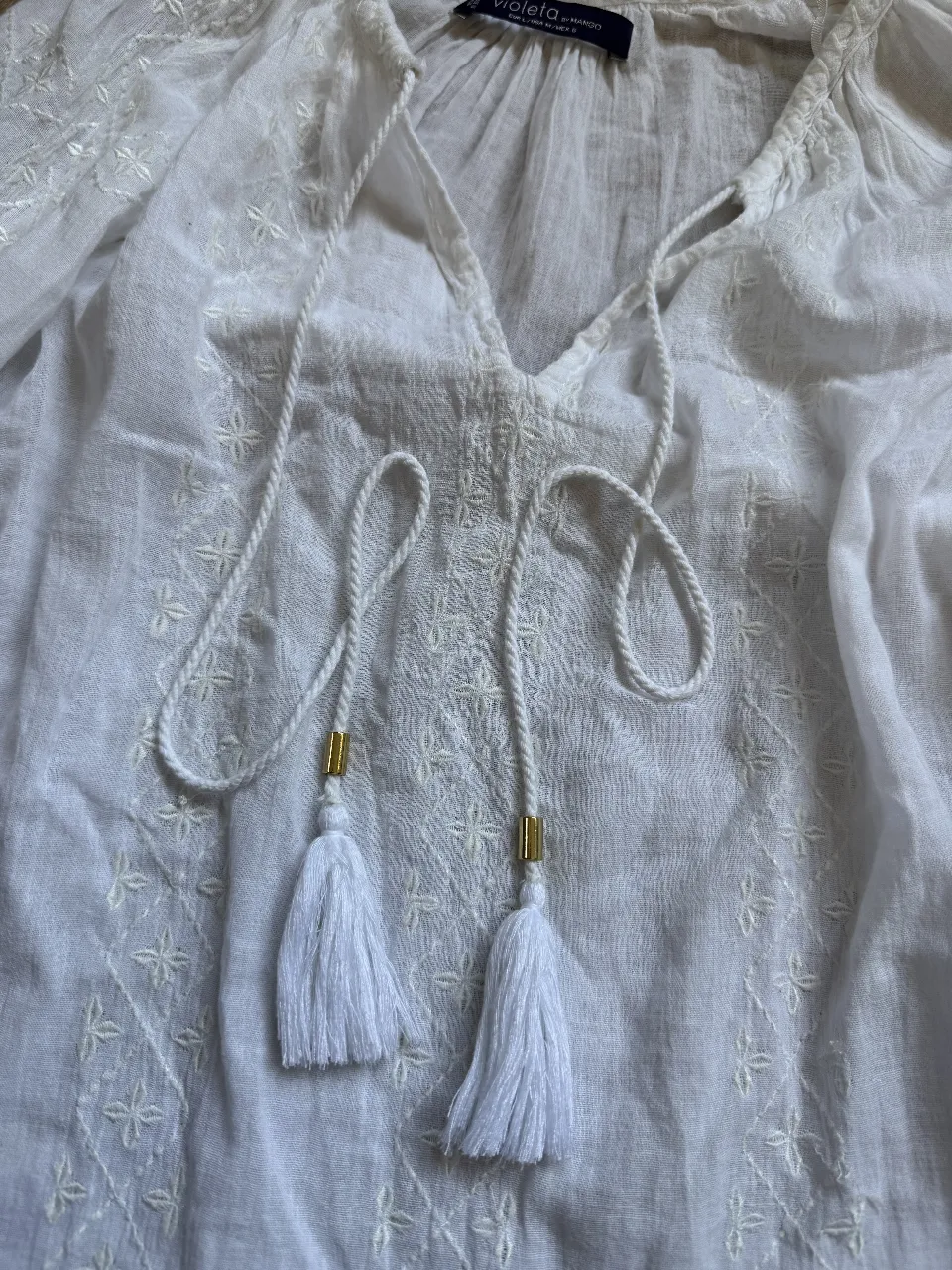 Blusa blanca de manga larga con bordados y detalles de borlas. De la marca Violeta by Mango, talle L. en el detalle de la ultima foto se puede ver un hilito salido. 