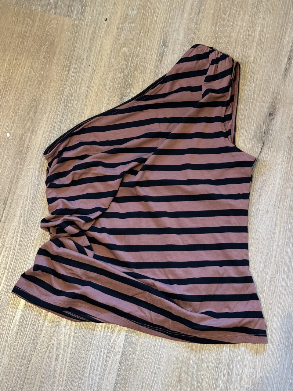 Remera de morley a rayas, con un solo hombro y detalle de fruncido lateral. Ideal para un look canchero y moderno.