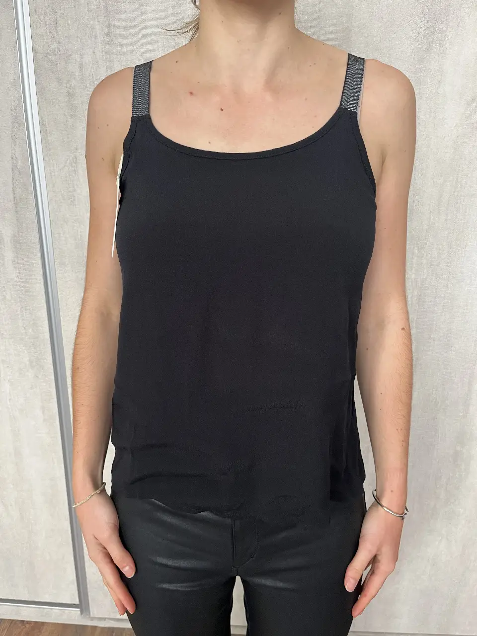 Musculosa negra de mujer, con tiras plateadas. Espalda descubierta en V. Ideal para un look casual y moderno.
