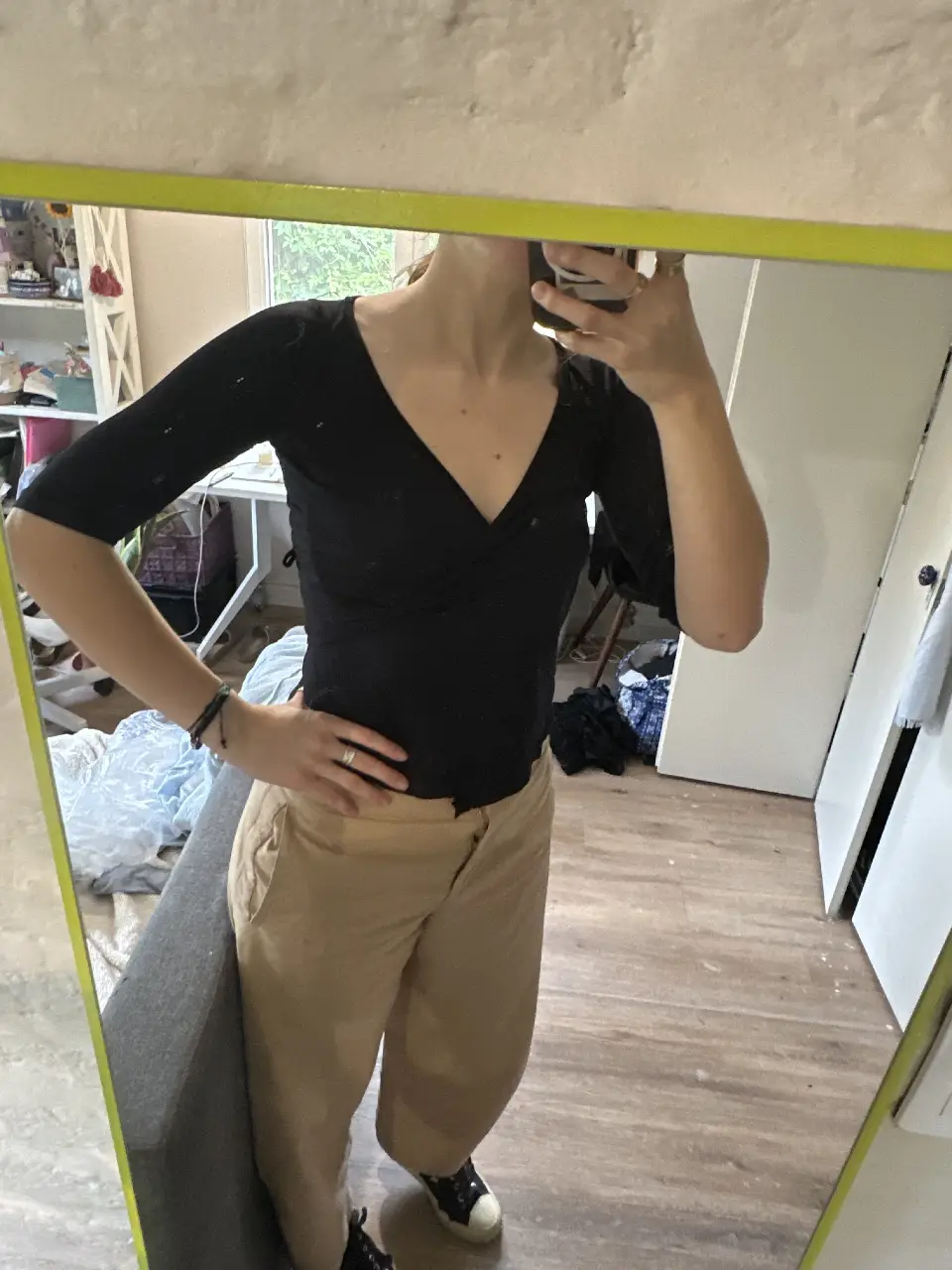 Blusa negra con escote en V y mangas 3/4. Ideal para un look elegante y versátil.