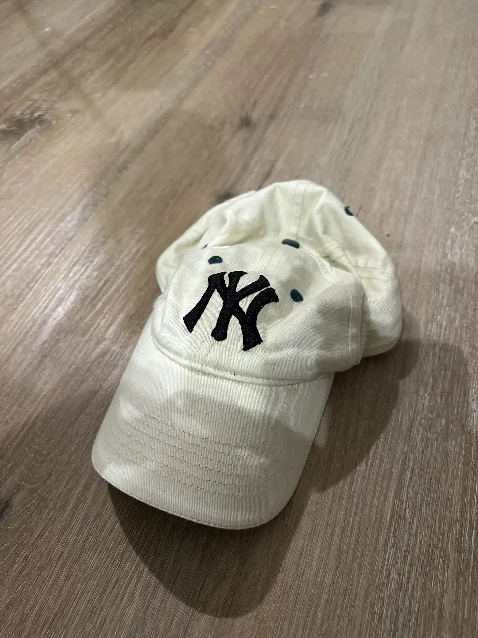 Gorra de béisbol de los New York Yankees en color blanco con el logo "NY" en negro. Ideal para un look casual y deportivo.