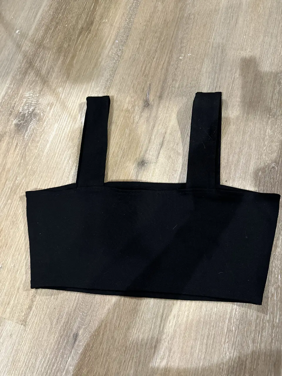Top negro con breteles anchos, ideal para un look casual o para combinar con otras prendas. Perfecto para el verano.