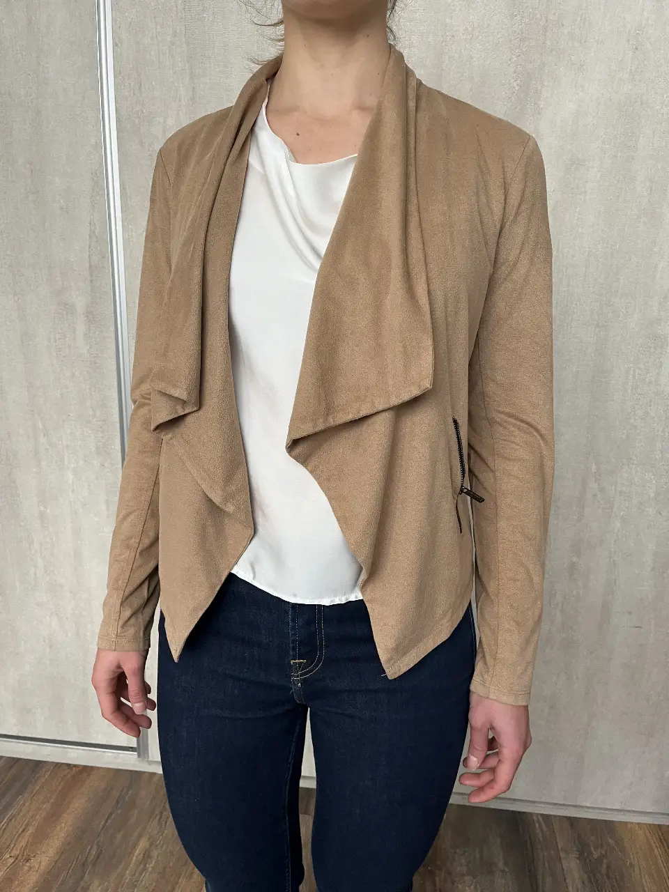 Chaqueta de mujer de gamuza sintética color camel, con solapas amplias y cierre en un bolsillo. Ideal para un look casual y elegante. Tiene una manchita en el cuello. 