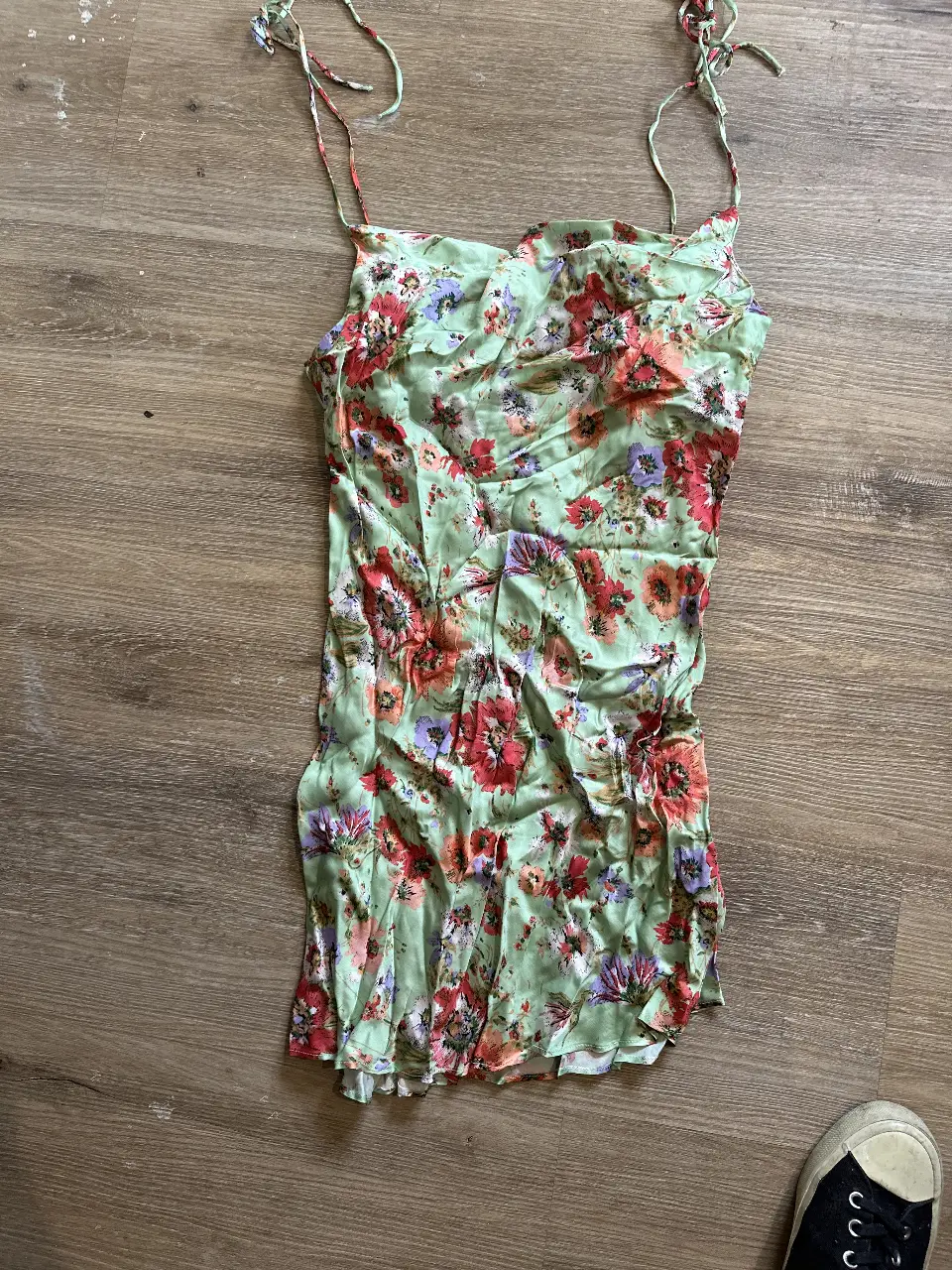 Vestido corto de seda con estampado floral en tonos verdes, rojos y morados. Ideal para un look fresco y femenino.