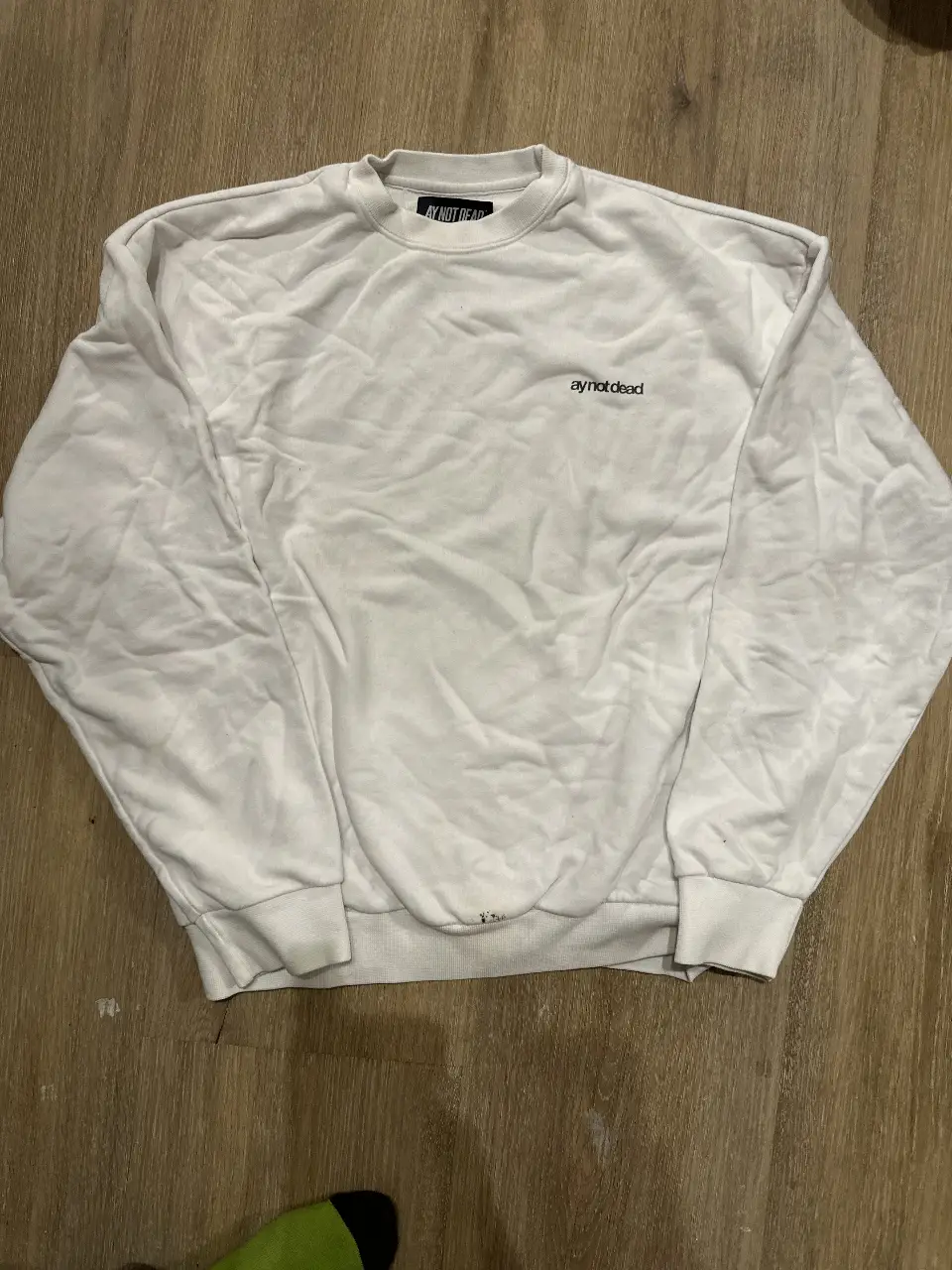 Buzo de cuello redondo blanco con logo "ay not dead" bordado. Talle L. Ideal para un look casual y cómodo.