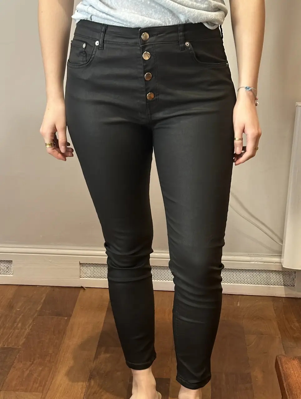 Jeans de mujer negros, tiro alto, con botones dorados. Talle 12, de la marca Zara. Ideal para un look casual y moderno.