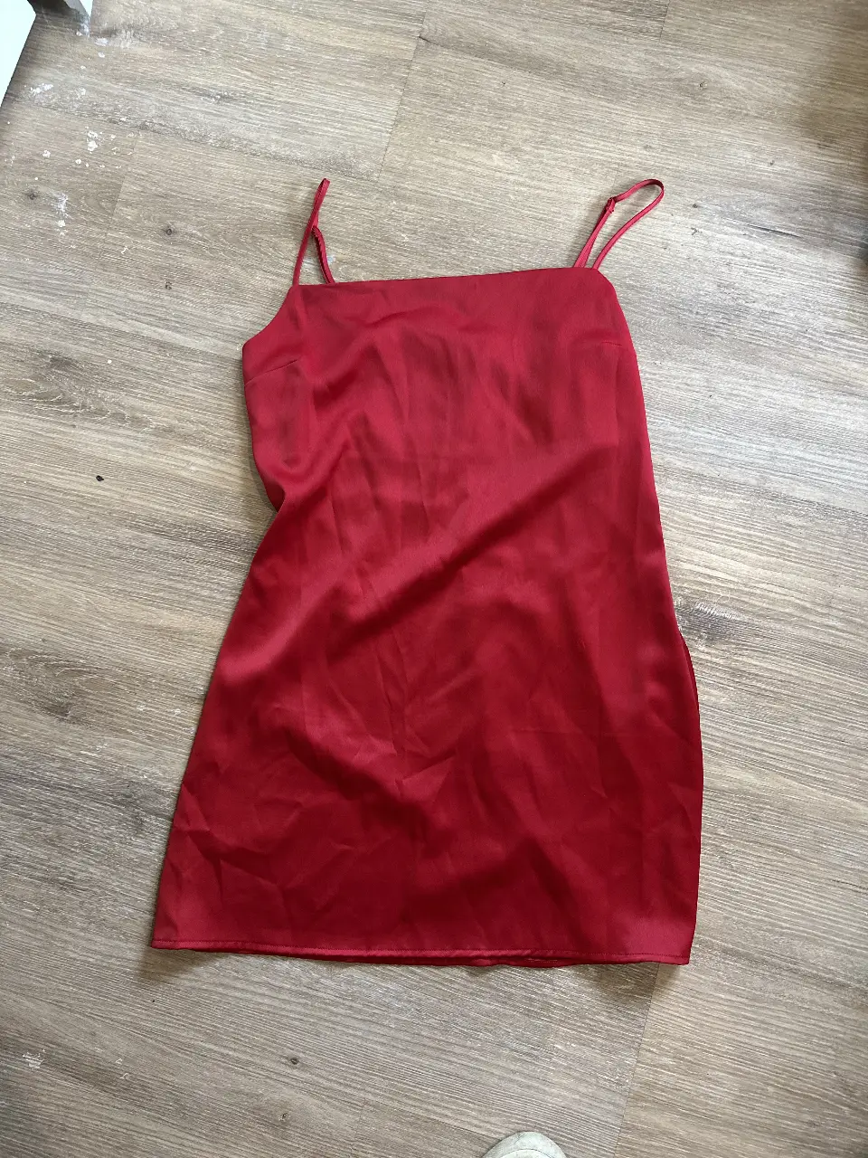 Vestido rojo de satén, con tirantes finos y cierre en la espalda. Ideal para una salida nocturna o evento especial.