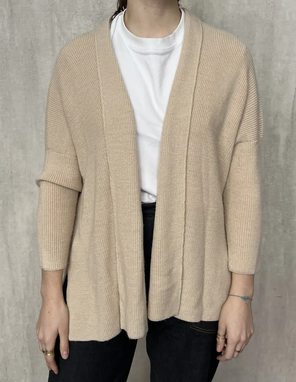 Cardigan de punto color crudo, con mangas amplias y corte holgado. Ideal para un look casual y cómodo.