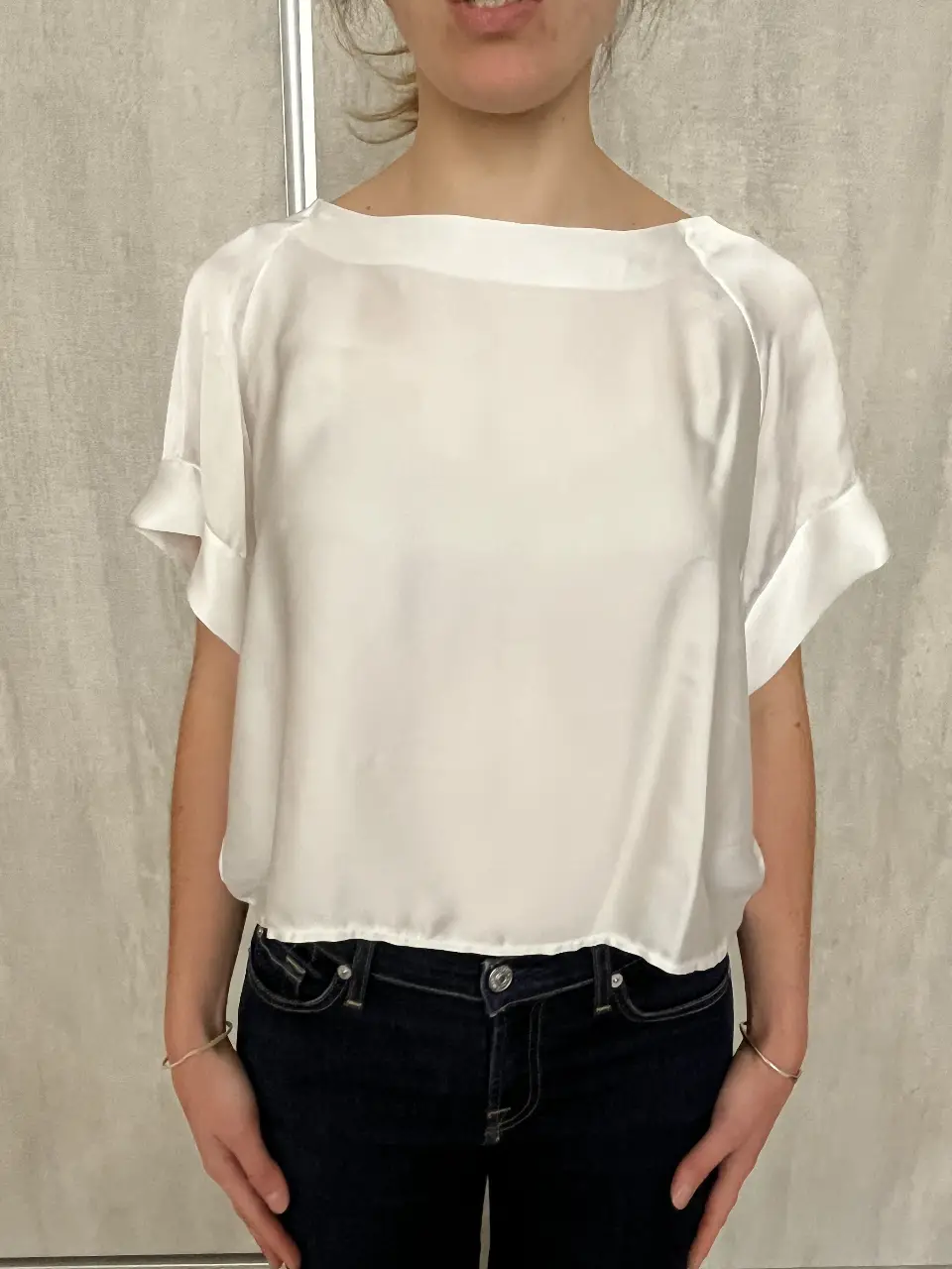 Blusa de seda blanca, con mangas cortas y cuello redondo. Ideal para un look elegante y sofisticado.
