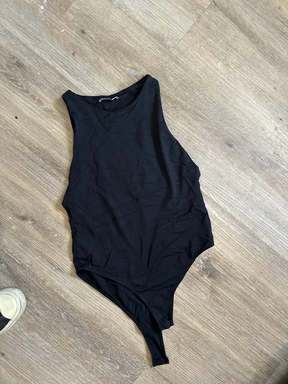 Body negro de mujer, sin mangas, escote redondo y corte cavado. 
