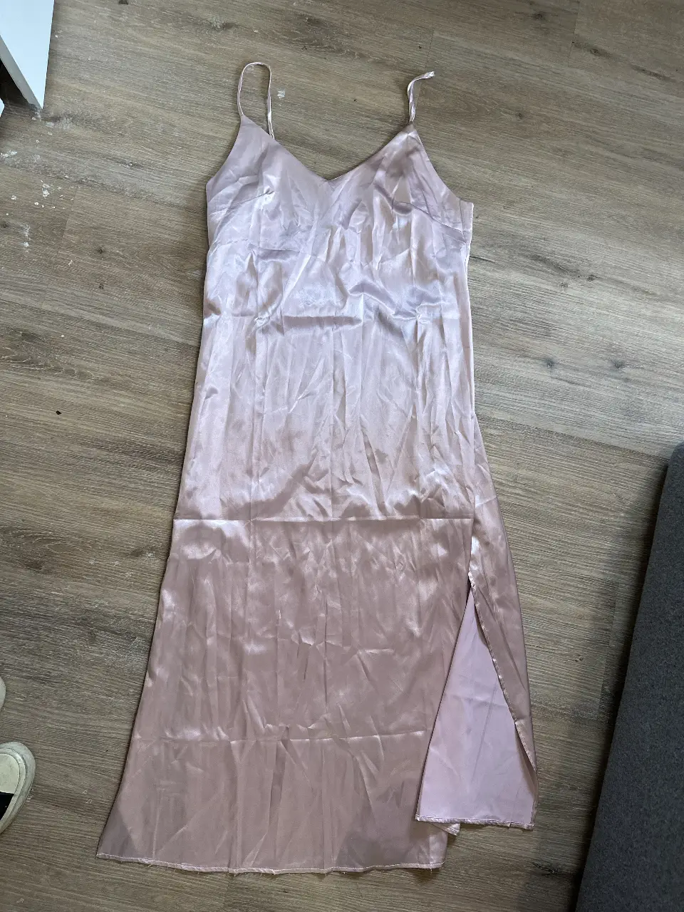 Vestido largo de satén color rosa, con tirantes finos y abertura lateral. Ideal para una ocasión especial.