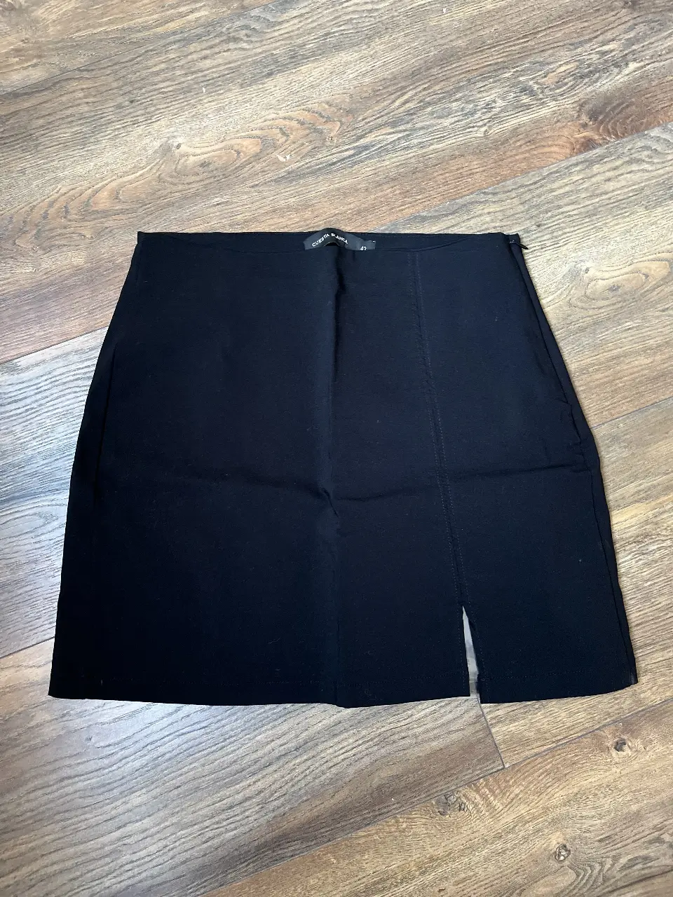 Minifalda negra con abertura en la pierna. Ideal para un look casual o de fiesta.