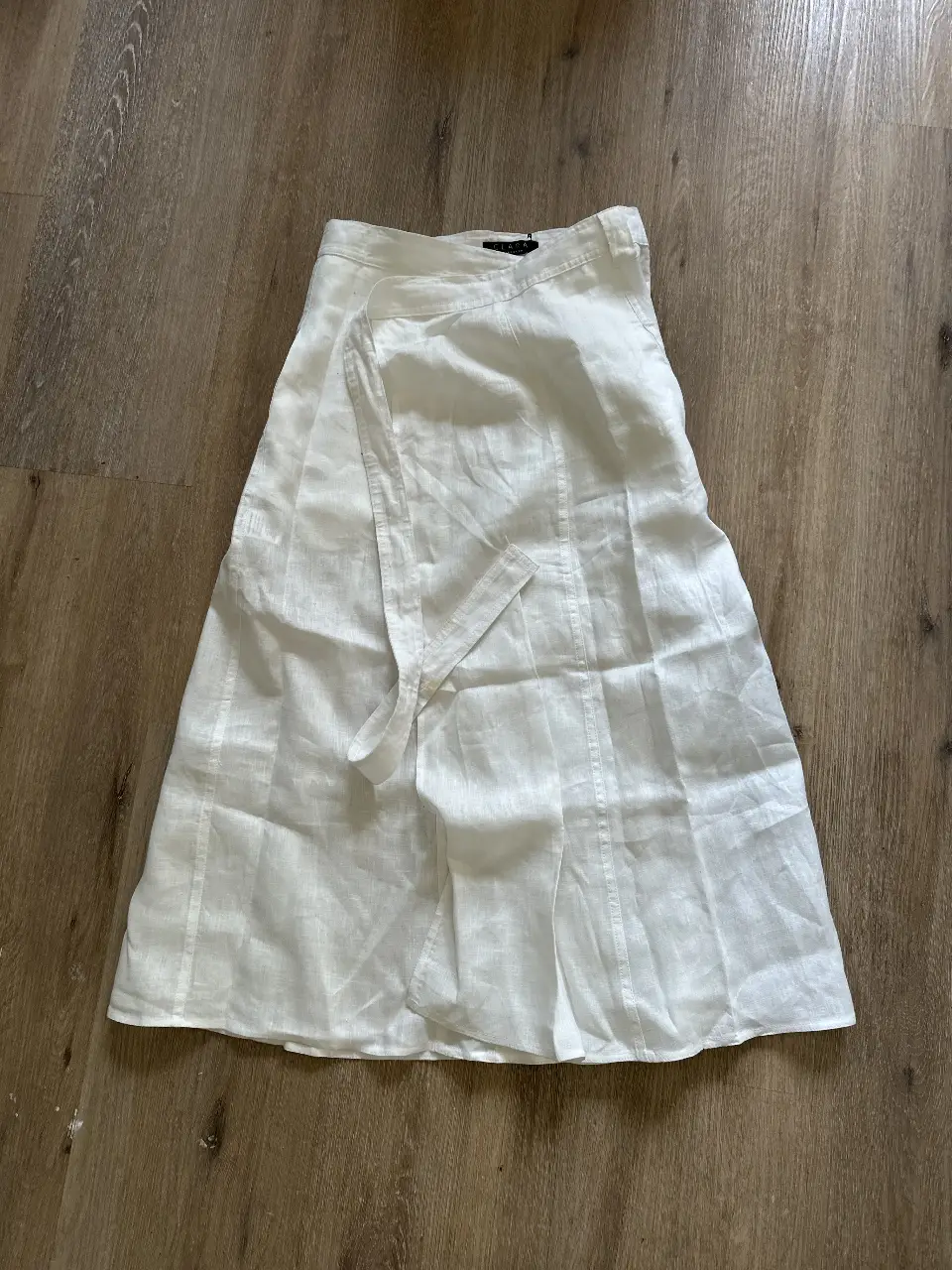 Pollera larga de lino blanca con detalle de lazo en la cintura. Talle 42. Tiene una mancha en el lazo de cafe. 