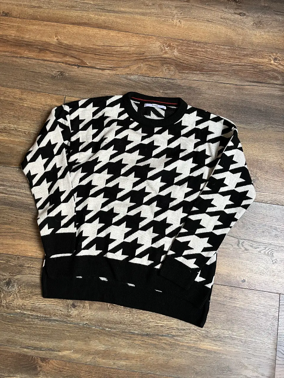 Sweater de tejido con estampado de pata de gallo en blanco y negro. Cuello redondo y puños y cintura en color negro.