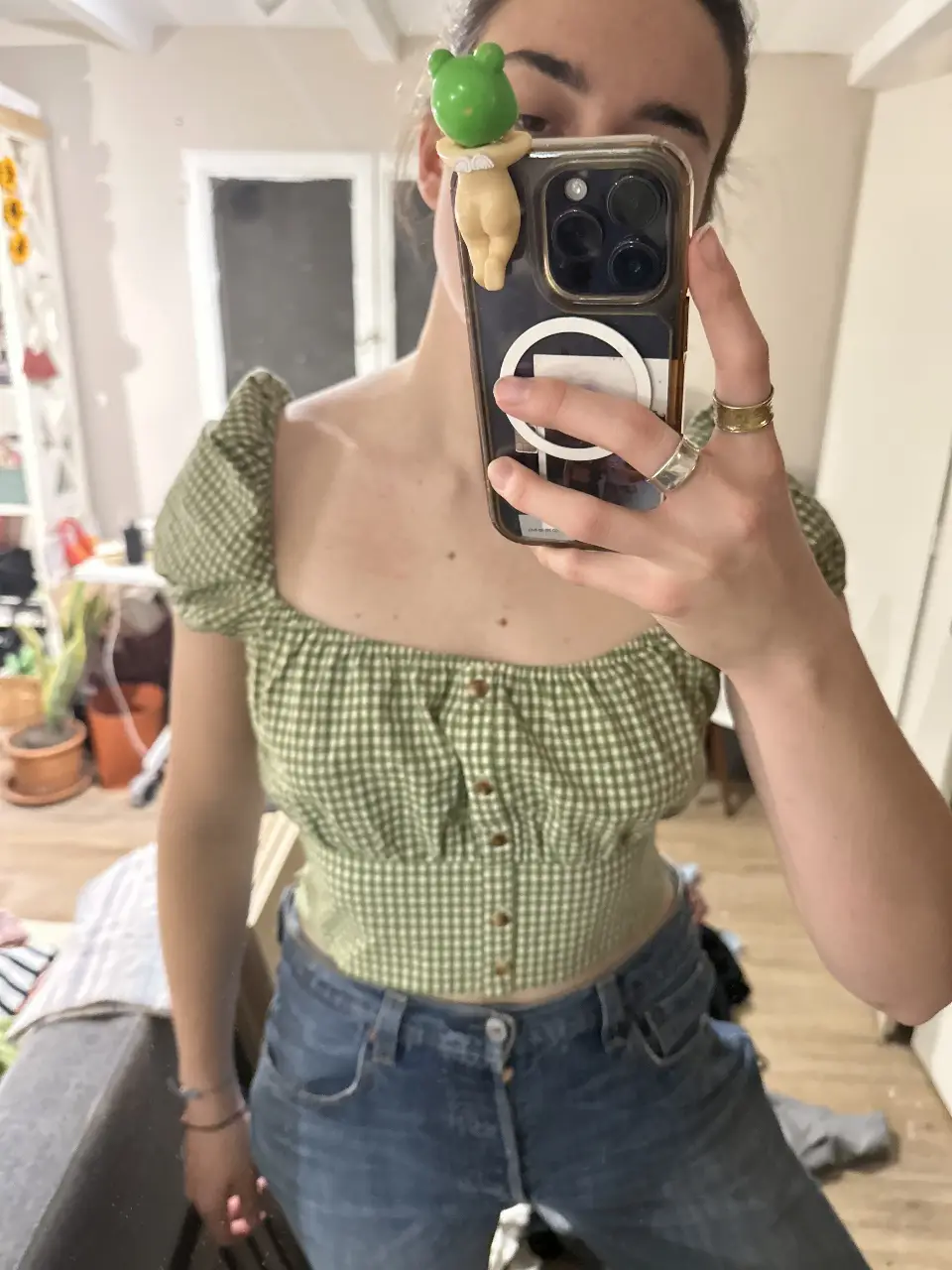 Blusa crop con estampado de cuadros vichy en verde y blanco. Diseño con mangas abullonadas y botones delanteros. Ideal para un look fresco y casual.