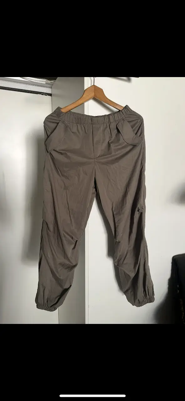 Pantalón tipo rompevientos, color marrón, con cintura elastizada y bolsillos laterales. Talle M (puede ser L) de la marca Zara. Ideal para un look casual y cómodo.