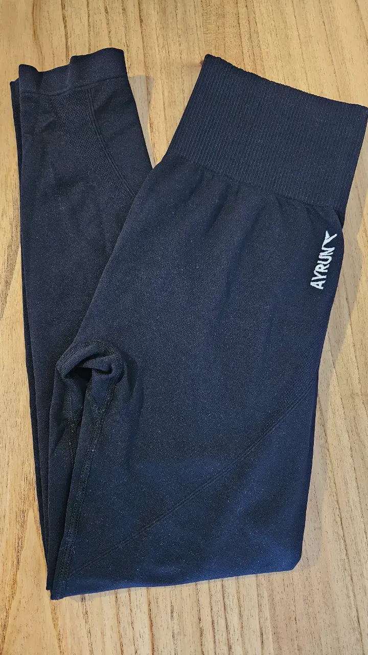 Calzas deportivas negras de cintura alta, con logo AYRUN en blanco. Ideales para entrenamientos y actividades físicas.