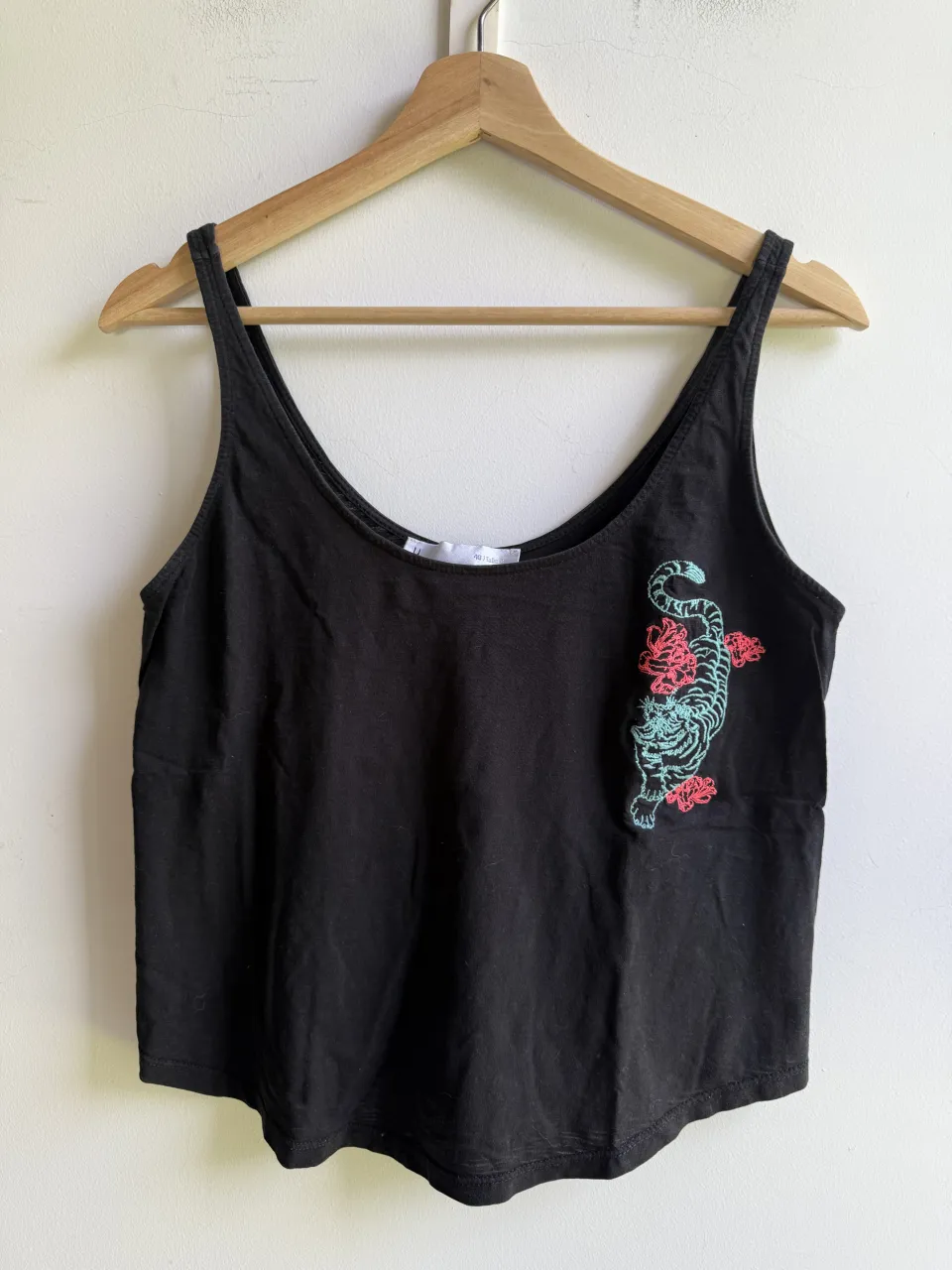 Musculosa negra con bordado de tigre y flores en color turquesa y rosa. Ideal para un look casual y canchero.