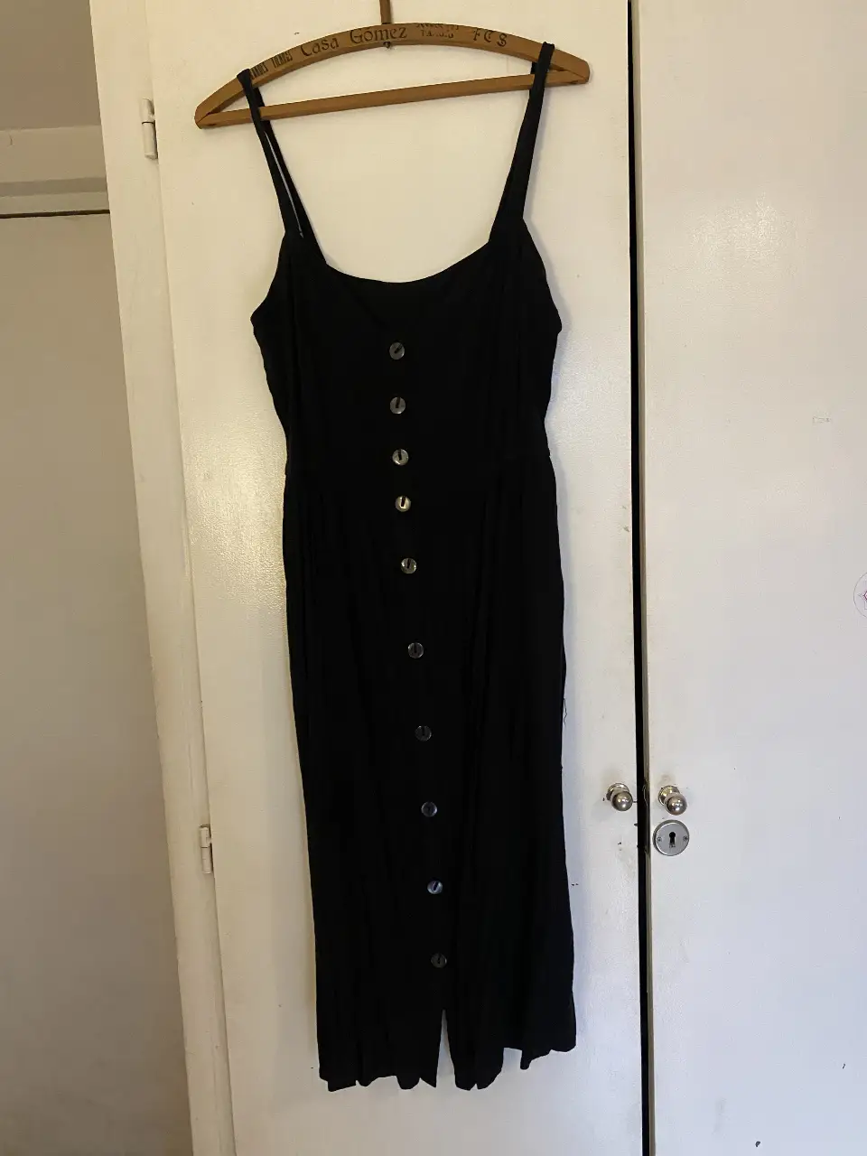 Vestido midi negro con botones frontales y tirantes finos. Ideal para un look fresco e informal de verano. Tiene poco uso pero un par de detalles (ver foto)