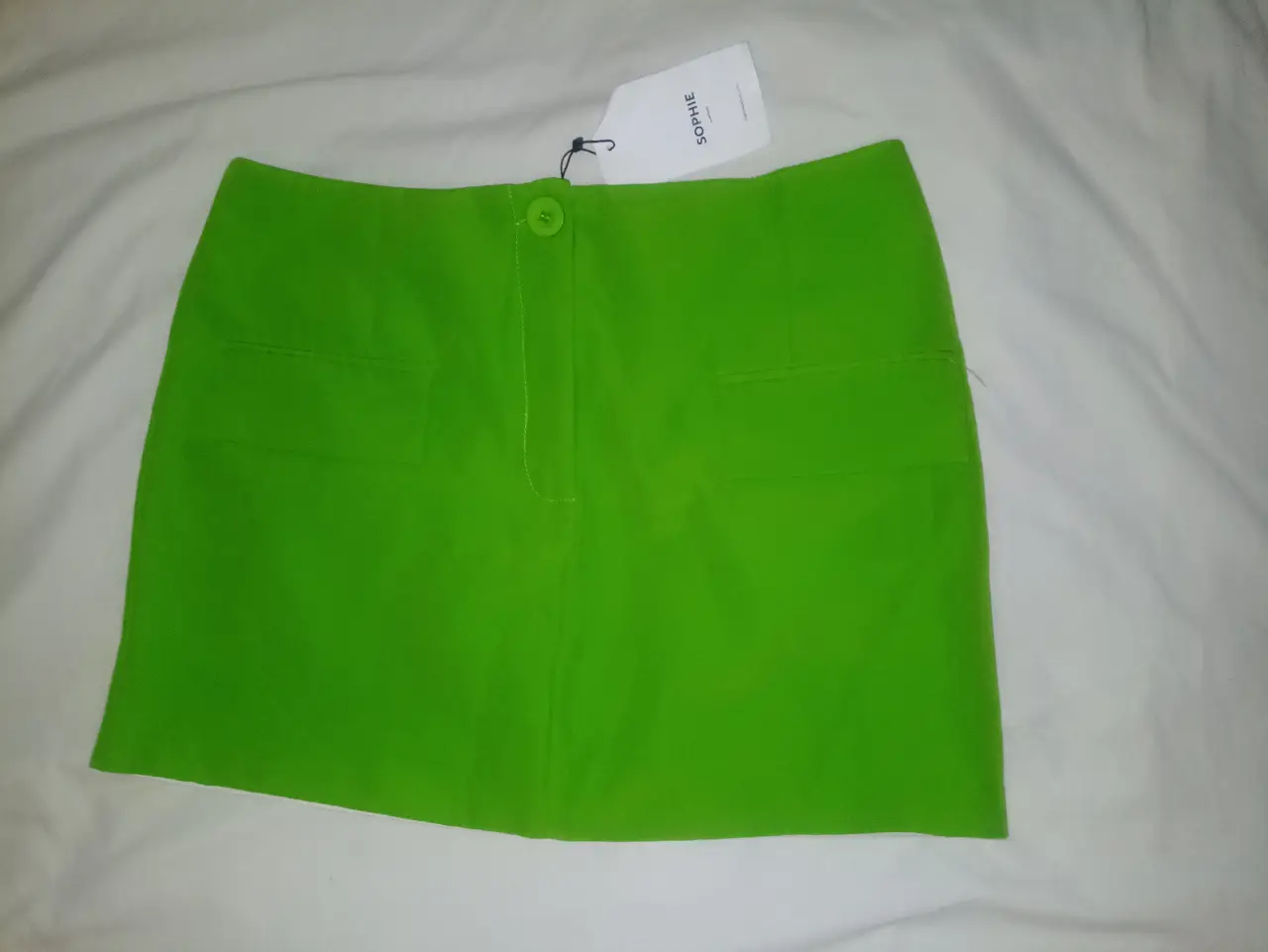 Pollera verde de la marca Sophie, con dos bolsillos delanteros y uno trasero. Cierre y botón en la parte delantera. Ideal para un look casual o para salir.