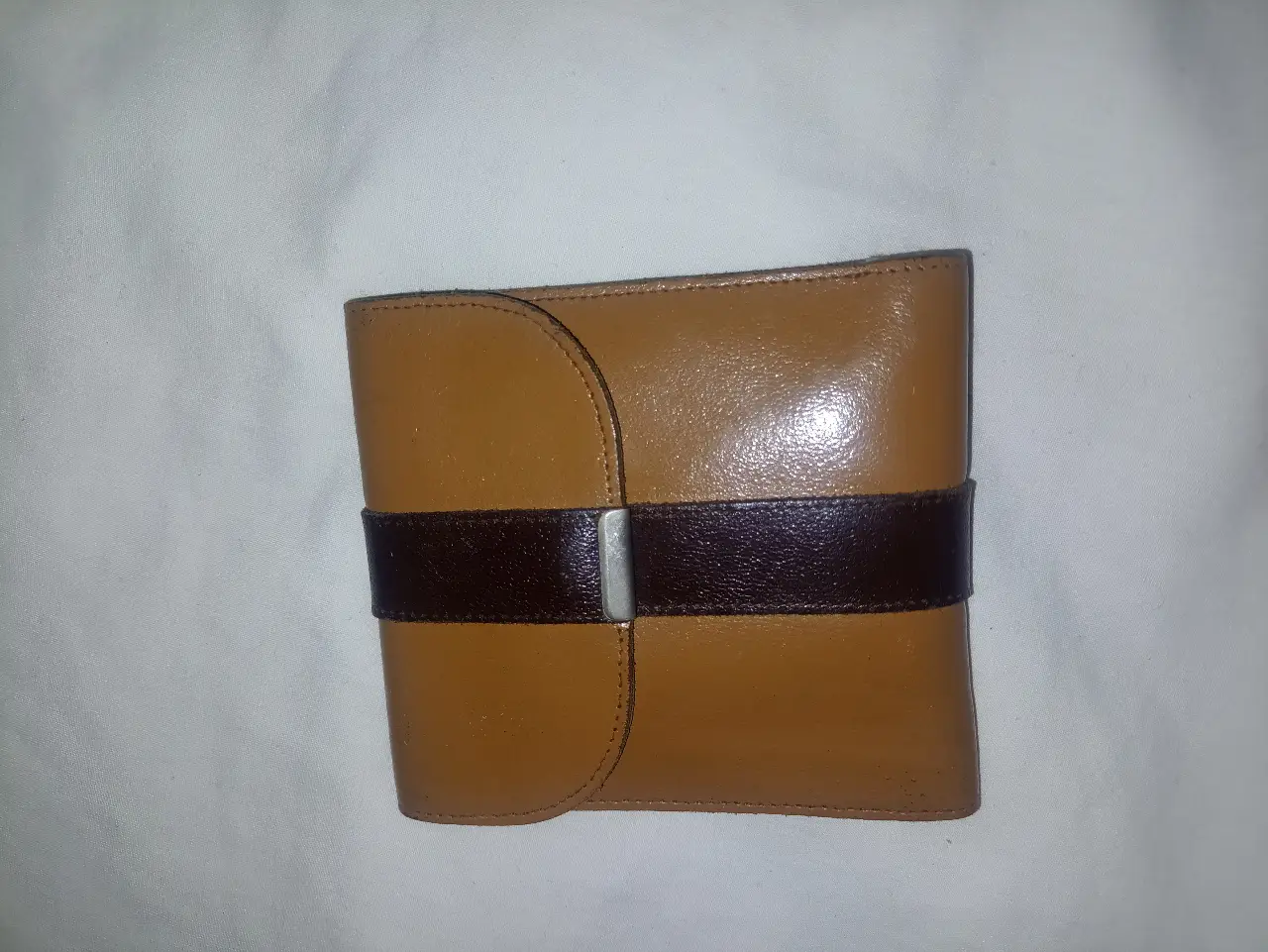 Billetera unisex  de cuero marrón con detalles en marrón oscuro y cierre con hebilla. Ideal para guardar tus pertenencias con estilo y seguridad. 