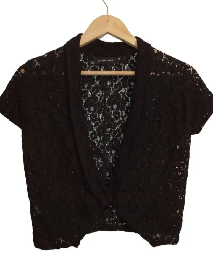 Blusa de encaje negro con mangas cortas. Ideal para un look elegante y sofisticado. Perfecta para combinar con diferentes outfits.