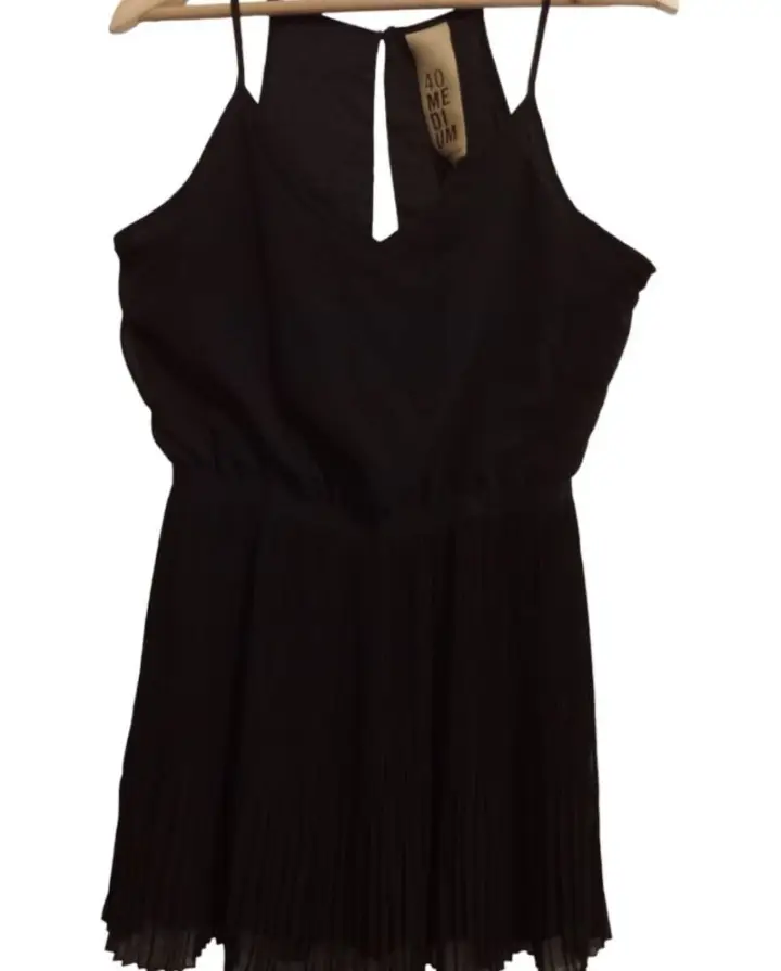 Vestido mini negro con detalles plisados y escote en V. Ideal para una salida o fiesta.