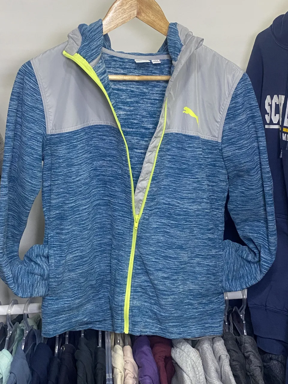 Buzo con cierre Puma, azul y gris con detalles en amarillo. Talle L.