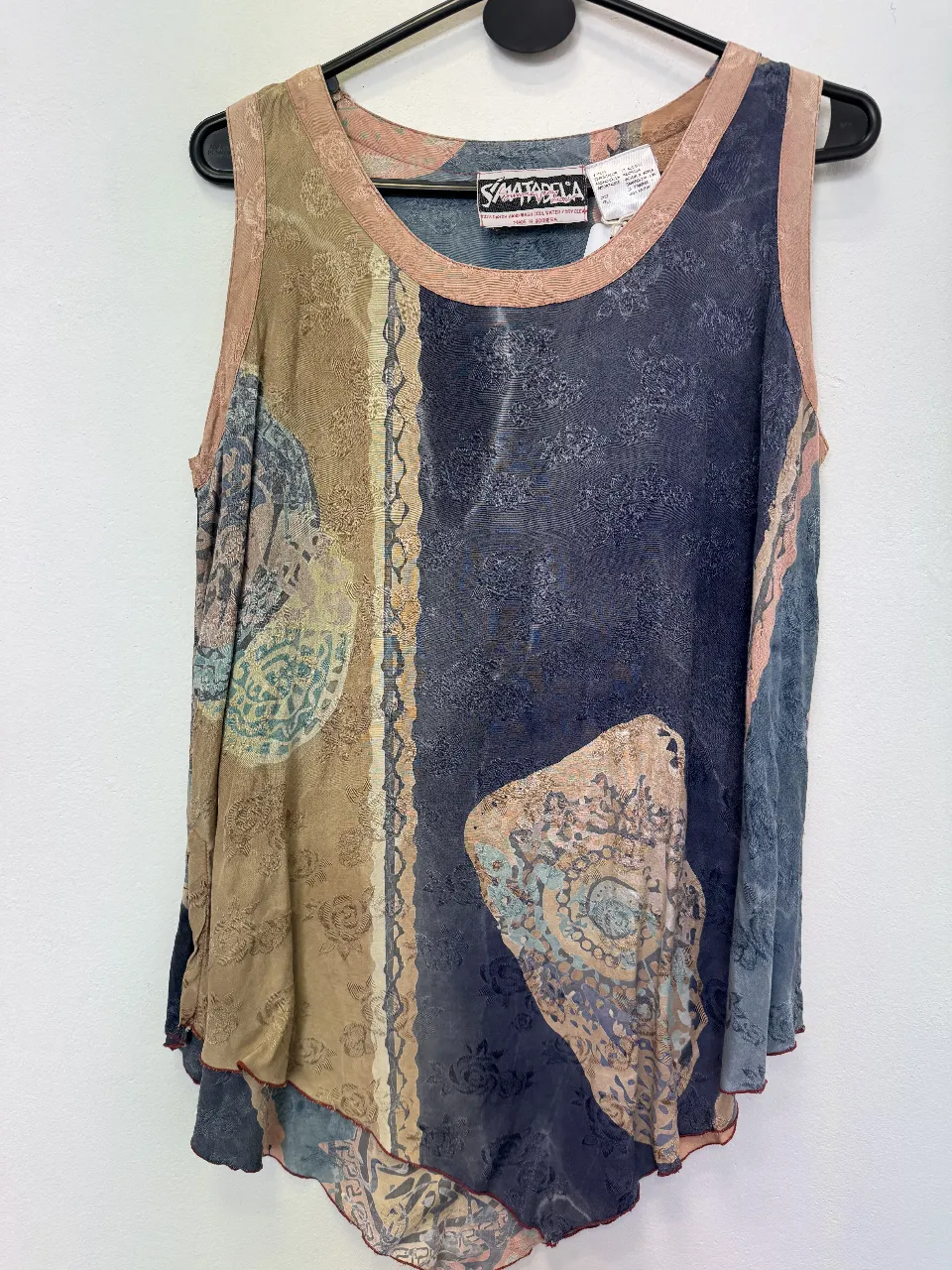 Musculosa de mujer con estampado abstracto en tonos marrones, azules y beige. Diseño vintage con detalles de costura y borde en color rosa. Ideal para un look bohemio y casual.
