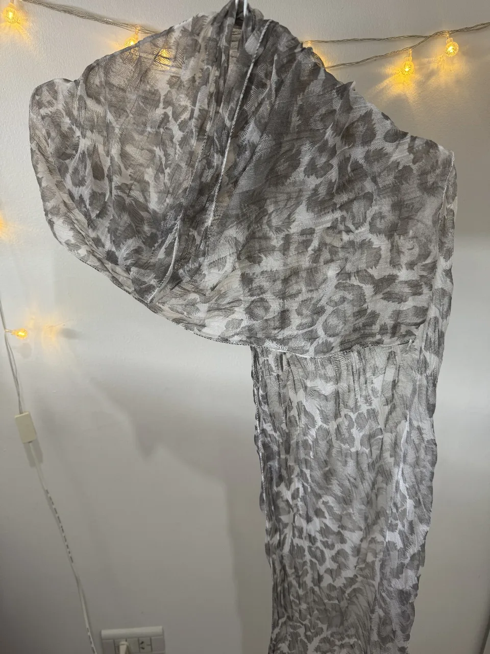 Pañuelo de gasa con estampado de leopardo en tonos grises y blancos. Ideal para complementar cualquier look, ligero y versátil.