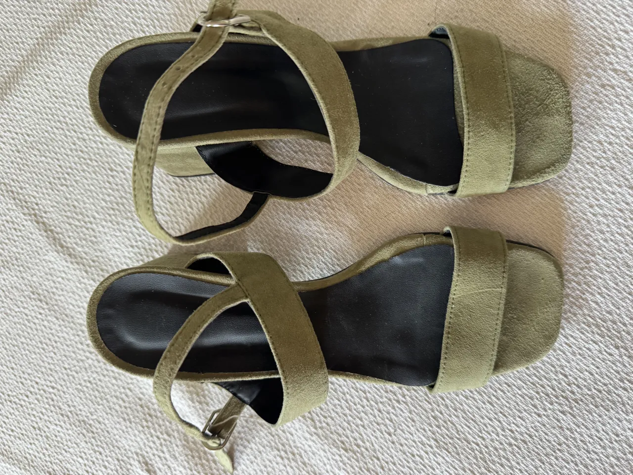 Sandalias de gamuza color verde militar, con tiras finas y hebilla regulable. Taco cuadrado y suela antideslizante. Ideales para un look canchero y moderno.