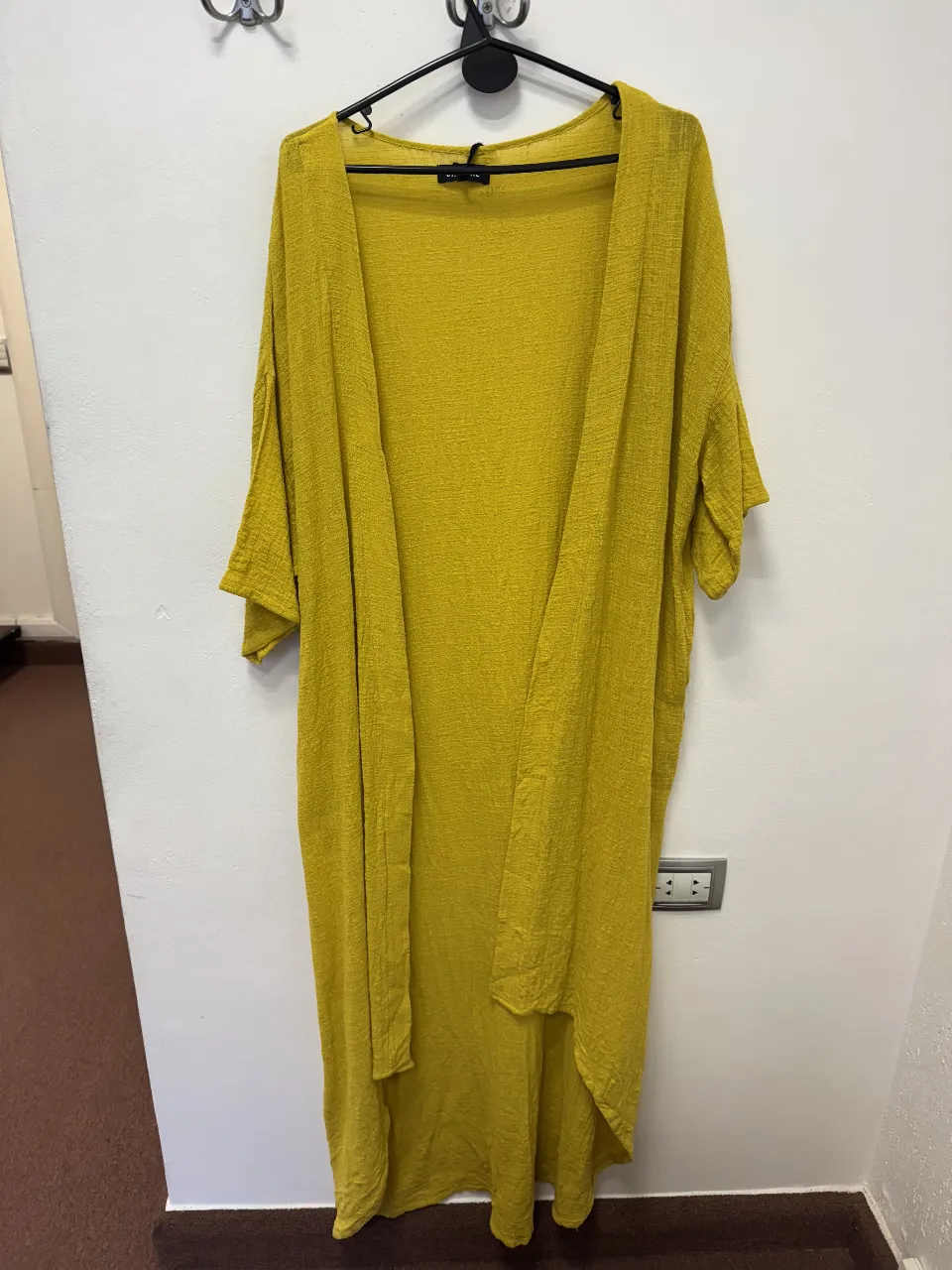 Kimono largo de color amarillo mostaza, con mangas amplias y bolsillos laterales. Ideal para un look casual y cómodo.