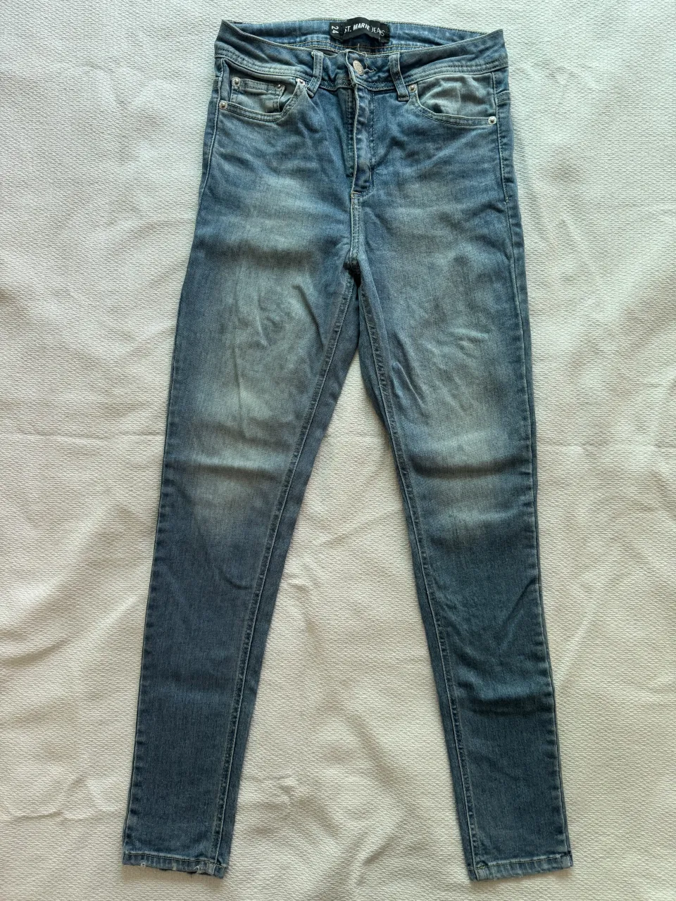 Jeans de tiro alto, color azul desgastado. Presentan bolsillos delanteros y traseros.