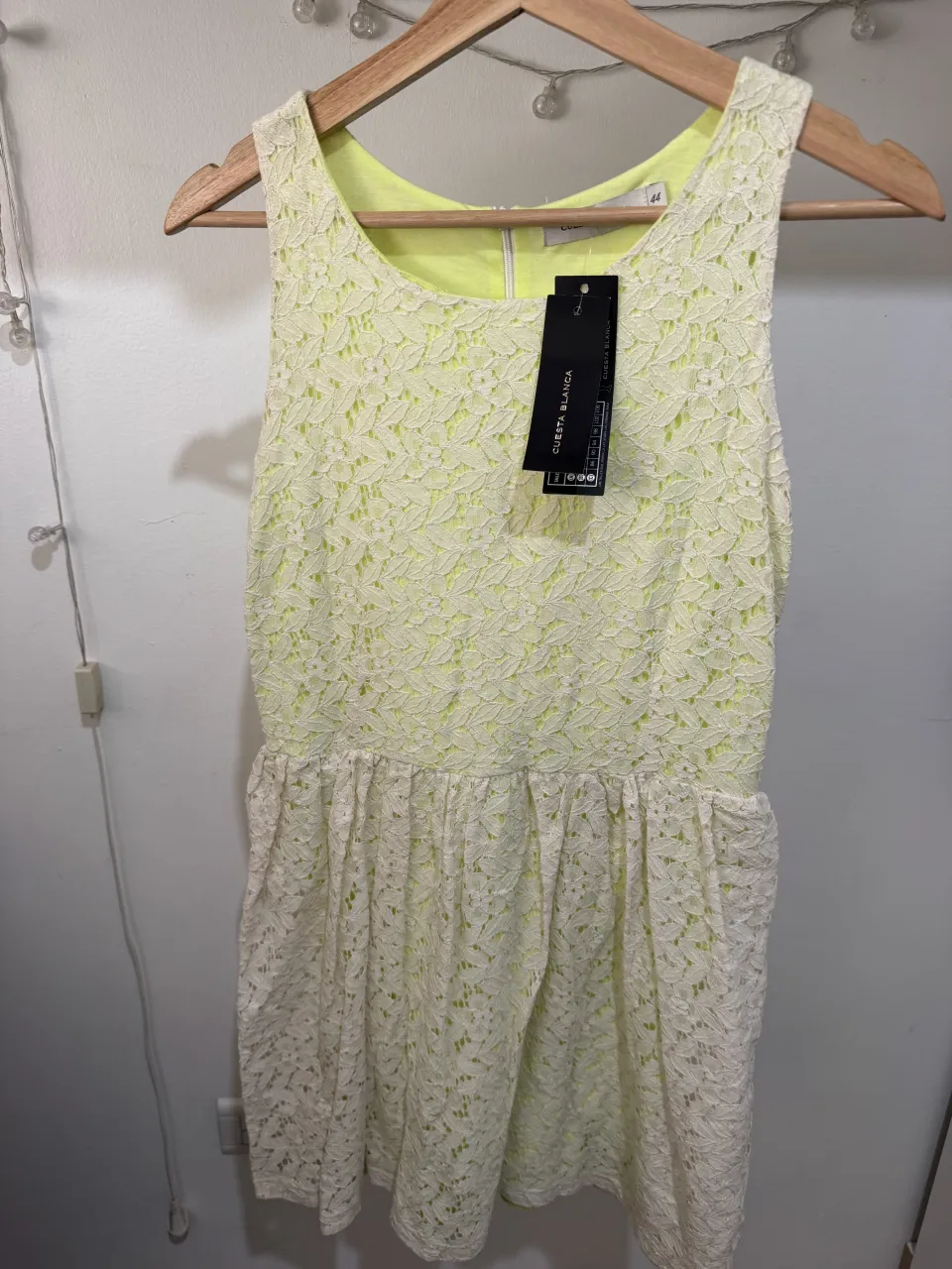 Vestido corto de encaje amarillo con forro interno de color verde lima. Posee cierre en la espalda.