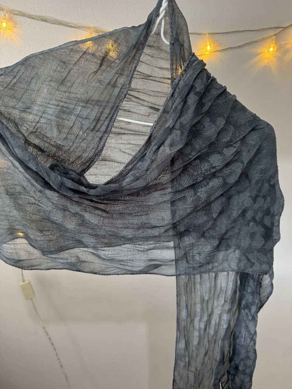 Pañuelo de gasa gris oscuro, ideal para complementar cualquier look. Su tejido ligero y delicado lo hace perfecto para usar en cualquier estación.