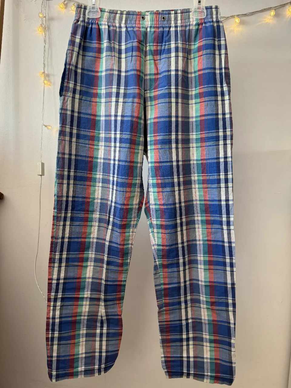 Pantalón de hombre, de tela suelta con estampado a cuadros en tonos azules, rojos y verdes. Ideal para un look casual y cómodo.
