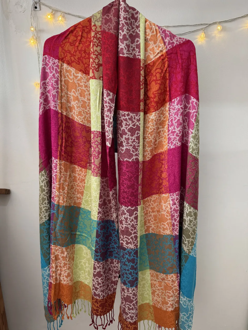 Bufanda de tela con diseño a cuadros en tonos vibrantes como rojo, rosa, naranja, verde y azul. Ideal para agregar un toque de color y estilo a cualquier atuendo.