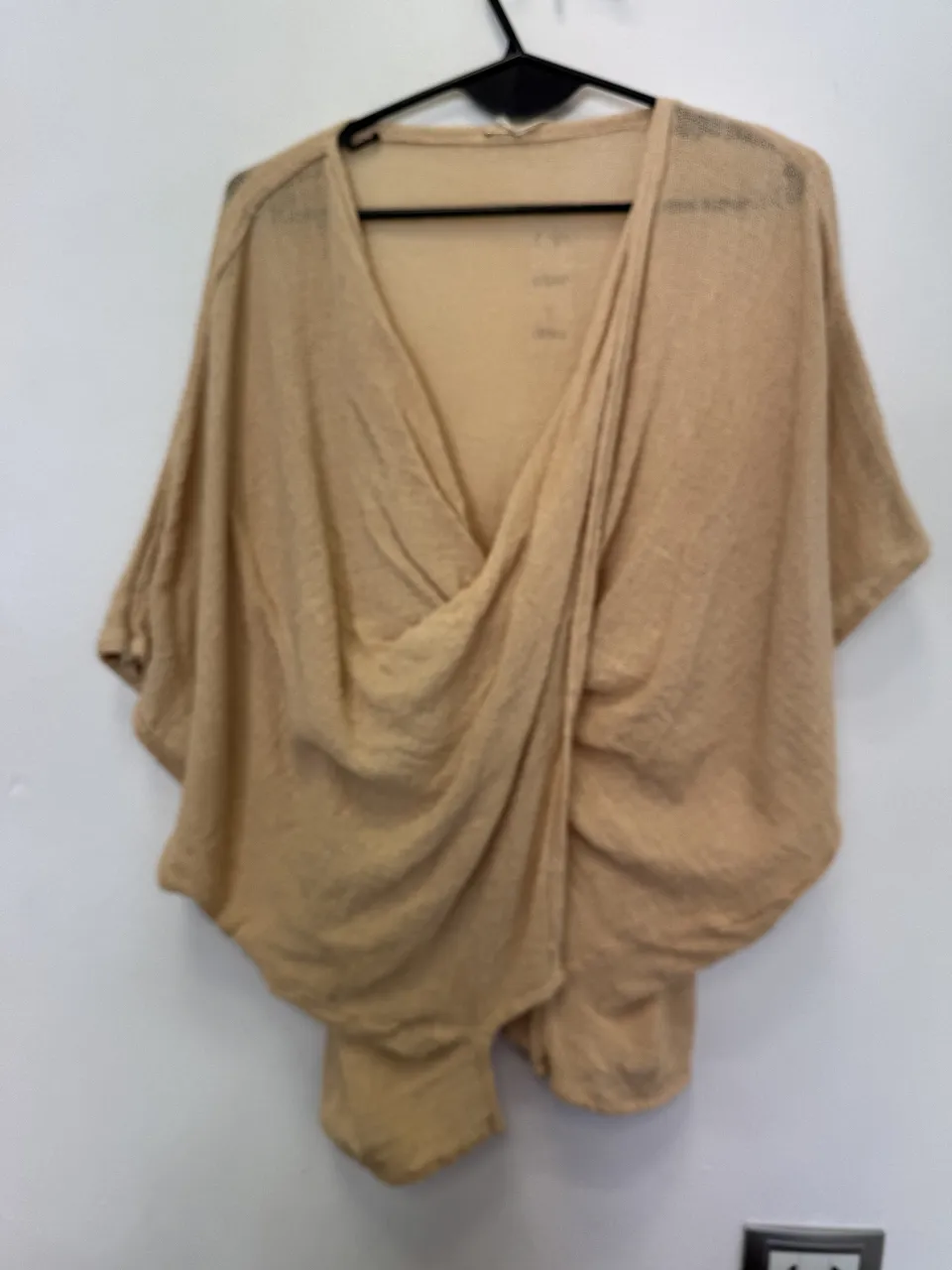 Blusa de mujer color crudo con diseño envolvente y mangas amplias. Ideal para un look casual y cómodo.