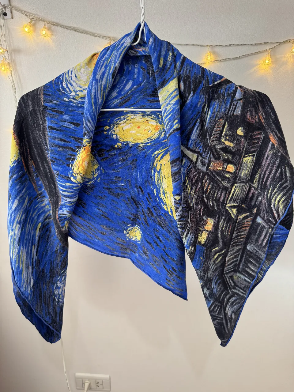 Pañuelo de seda con estampado del cuadro "La Noche Estrellada" de Van Gogh. Ideal para darle un toque artístico y sofisticado a cualquier look. Perfecto para usar en cualquier estación.