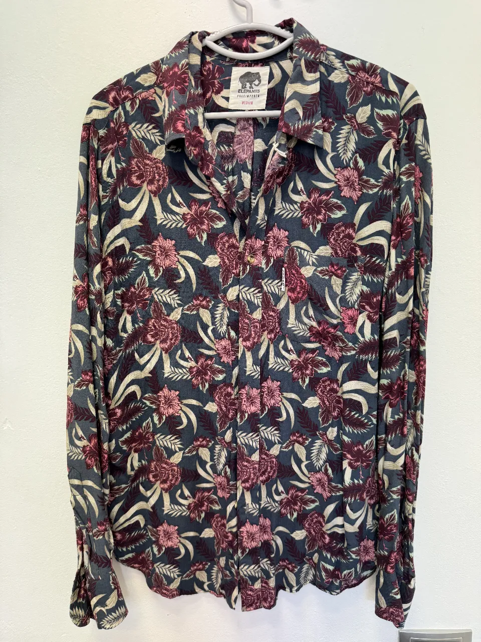 Camisa estampada, con un diseño floral en tonos azules, borgoña y rosa. Manga larga, con bolsillo en el pecho y cuello clásico. Ideal para un look casual y con estilo.