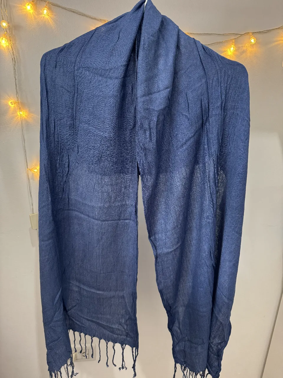 Bufanda de tela azul oscura, ideal para complementar cualquier look. Su diseño versátil la hace perfecta para usar en diferentes ocasiones.