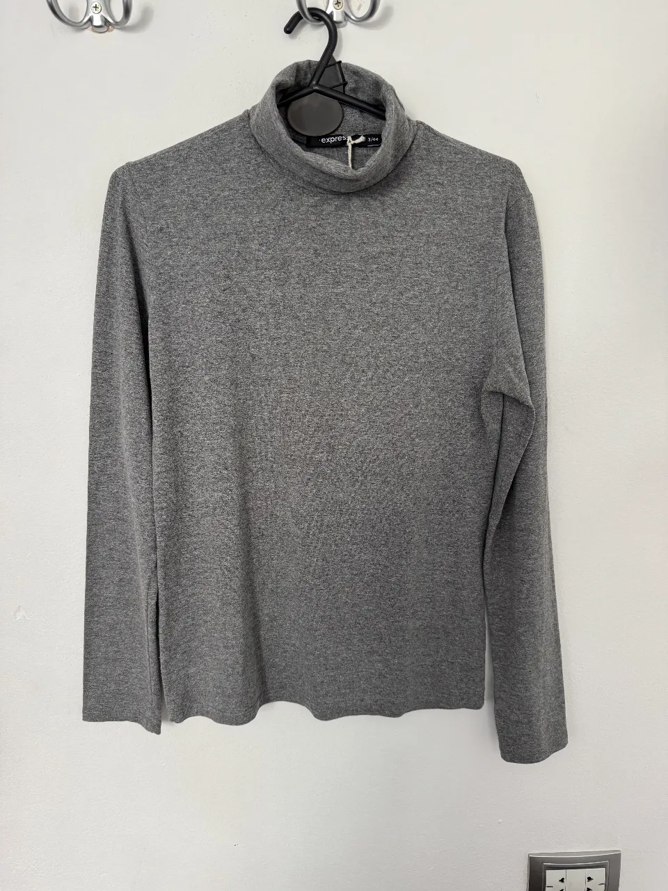 Remera de cuello alto gris de la marca Express, ideal para el invierno. Es una prenda basica y versatil, perfecta para combinar con cualquier outfit.